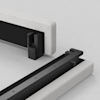 A close-up of two bed frame components on a light surface: one upright with a black metal bracket, and the other horizontal, ready to be connected, both upholstered in light gray fabric.