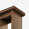 Close-up of the corner of a wooden table or desk with a dark, textured edge detail against a plain white background. The wood has a smooth finish and clean, modern lines.
