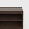 A close-up view of a dark brown wooden shelf unit with an open shelf and a flat top, against a plain white background.
