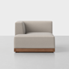 A modern, light beige sectional sofa corner piece with a wooden base, set against a plain white background.