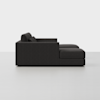 Side view of a modern, dark gray sectional sofa with a chaise lounge on the right, placed in a minimal, light-colored room with a plain background.