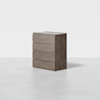 A modern, four-drawer wooden dresser with a light brown finish, standing on a smooth, light gray floor against a plain white background.