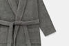 A close-up of a dark gray, long-sleeved bathrobe made from soft, textured fabric. The robe features a belt tied at the waist and two large front pockets, shown against a plain white background.