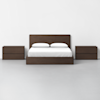 A modern bedroom setup with a dark wood bed frame, white bedding, and two matching dark wood nightstands on either side, all set against a plain white wall and light grey floor.