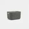 A gray, rectangular felt storage bin with rounded corners and a cutout handle on one side, placed on a plain white background.