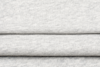 Close-up of folded light gray fabric with a soft, slightly textured surface. The image shows two visible folds, emphasizing the material’s smooth and cozy appearance.