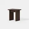 A small, modern wooden side table with a rectangular top and flat, solid legs, shown against a plain white background. The wood has a dark brown finish.