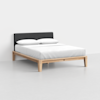A modern bed with a light wood frame, white bedding, two white pillows, and a dark upholstered headboard, set against a plain white background.