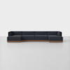 A modern, dark navy sectional sofa with clean lines and wooden base, arranged in a spacious, minimalist room with a light gray floor and white background.