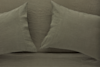 Two olive green linen pillowcases on a matching bedsheet, arranged side by side with a subtle texture visible on the fabric.
