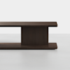 A modern, minimalist wooden table with a dark finish, featuring a thick rectangular top and base connected by a central vertical support, shown against a plain white background.