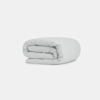 A neatly folded light gray comforter is placed on a plain white background.