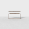 A minimalistic, rectangular wooden side table with an open, geometric frame and a floating top panel, set against a plain white background.