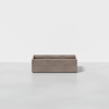 A rectangular wooden storage box with an open top, placed on a light gray floor against a plain white background.