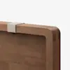 Close-up of a wooden headboard with rounded edges, featuring a light beige fabric strap attached over the top edge against a plain white background.