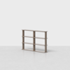 A minimalist wooden bookshelf with three shelves and a light brown finish, standing on a plain, light-colored floor against a white background.