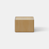 A modern wooden nightstand with a single drawer partially open, set against a plain white background. The design is minimalistic with smooth surfaces and rounded edges.