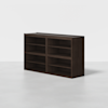 A dark brown wooden shelving unit with eight open compartments, placed on a light gray floor against a plain white background.