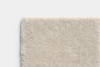 A close-up view of a rectangular light beige textured carpet sample with a soft, plush pile set against a plain white background.