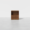 A minimalist wooden nightstand with an open shelf on top and two drawers below, set against a plain white background.