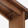 Close-up view of a wooden table’s underside, showing smooth joinery, hardware, and a rich brown finish. Two black adjustment knobs are visible, integrated neatly into the structure.