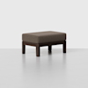 A rectangular ottoman with a brown cushioned top and dark wooden legs, set against a plain light gray background.