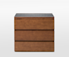 A modern wooden dresser with three drawers and a smooth dark gray top, set against a plain white background.
