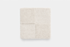 A square, cream-colored textured fabric sample divided into four equal sections, each with a slightly different shade and texture, placed on a plain white background.