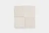 A square, cream-colored textured fabric sample divided into four equal sections, each with a slightly different shade and texture, placed on a plain white background.