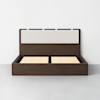 A modern wooden bed frame with a cushioned beige headboard, shown without a mattress, placed against a plain white wall on a gray floor.