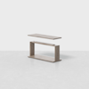 A modern wooden table with a rectangular top shown floating above its base, highlighting its two-piece construction on a light gray surface with a plain white background.