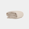 A neatly rolled, light beige comforter or blanket is displayed against a plain white background.