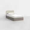 A single bed with a beige upholstered headboard and a simple wooden frame, dressed with white sheets and a pillow, placed in a minimalist, empty room with white walls and a light gray floor.