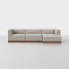 A modern L-shaped beige sectional sofa with clean lines, low backrests, and a wooden base, set against a plain white background.