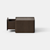 A dark brown, rectangular wooden box sits centered on a smooth, light gray surface against a plain white background.