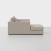 Side view of a modern light beige sectional sofa with clean lines, plush back cushions, and an extended chaise lounge on the right, set against a plain white background.