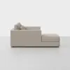 Side view of a modern light beige sectional sofa with clean lines, plush back cushions, and an extended chaise lounge on the right, set against a plain white background.