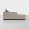 Side view of a modern, light beige upholstered chaise lounge with clean lines, two back cushions, and a wide seat, placed on a smooth, light gray floor against a plain white background.
