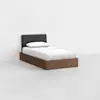 A modern single bed with a dark upholstered headboard, white bedding, and a wooden frame, positioned in a minimalistic, empty white room.