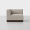 A modern, light beige upholstered corner sofa seat with clean lines and a dark wooden base, set against a plain white background.