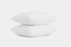 Two white pillows stacked neatly on top of each other against a plain white background.