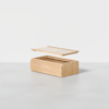 A light wood storage box with a rectangular shape and an open top, shown with its flat lid hovering above, against a plain white background.