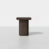 A minimalist, modern side table with a dark wood finish, featuring a rectangular top and a thick, cylindrical pedestal base, set against a plain white background.