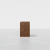 A minimalist, three-drawer wooden dresser is centered against a plain white background, viewed directly from the front.