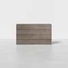 A modern, minimalist wooden dresser with eight drawers is set against a plain white background and a light gray floor.