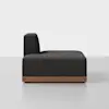 A modern armless black sofa with a wooden base, shown from the side against a plain white background.