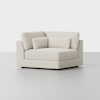 A modern, cream-colored corner sofa chair with plush cushions and a minimalist design sits on a plain, light-colored floor against a white background.