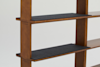 A close-up of a wooden shelving unit with dark gray shelves, shown against a plain white background. The shelves are supported by vertical wooden panels.