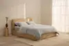 Two white pillows are stacked on top of a neatly folded white duvet, all set against a plain white background.