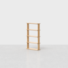 A simple, light wood bookshelf with four shelves stands on a grey, smooth floor against a plain white background. The bookshelf is empty and centered in the image.